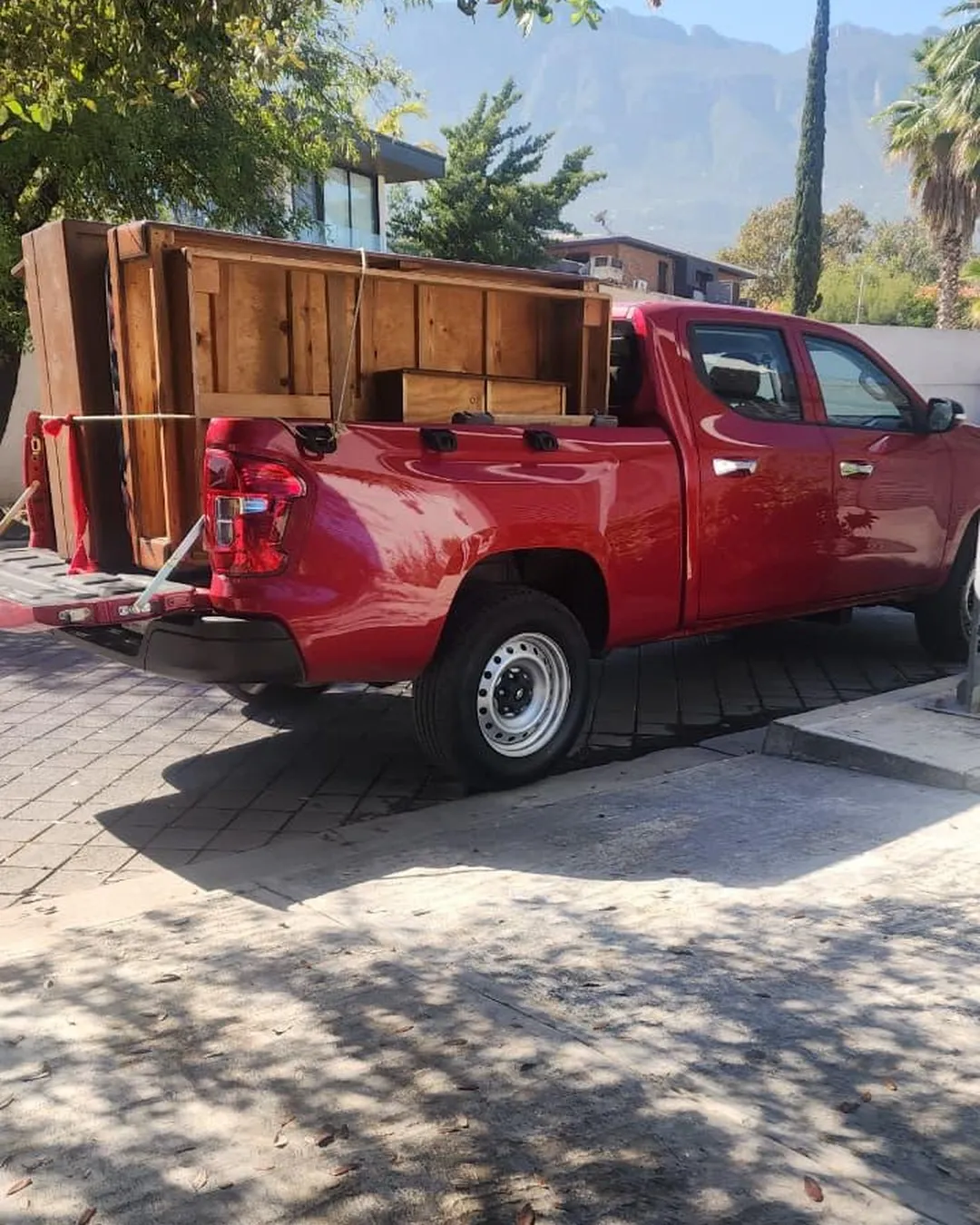 Pickup de FYS Monterrey cargada con un mueble grande de madera
